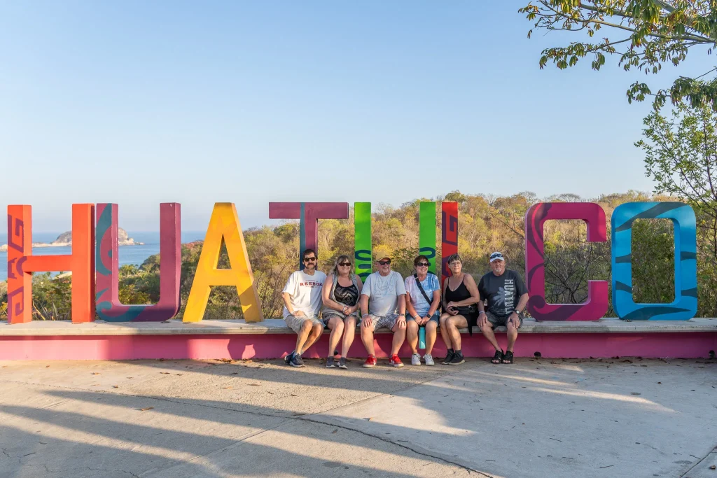 turistas posando en las letras de Huatulco mirador de tangolunda